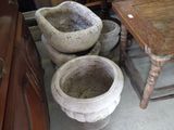three cement pots sitting on a table in a room