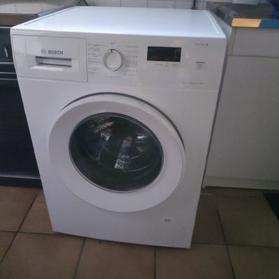 a white washing machine sitting in a kitchen next to a dishwasher