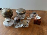 une table en bois sur laquelle sont posés des bocaux en verre et un bougeoir