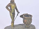 bronze figurine of a man with a dog and a pot