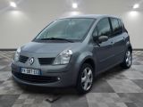 La petite voiture grise est garée dans le garage, sur un sol à damier.