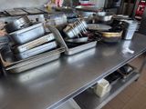 de nombreuses casseroles et poêles sur la table de la cuisine
