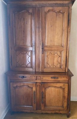 a wooden cabinet that is in the corner of a room