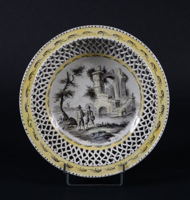 assiette jaune et noire sur laquelle est représenté un château