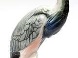 a figurine of a pelican sitting on a branch