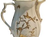 a white and gold coffee pot with birds on it