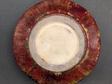 a red and white plate with a brown rim