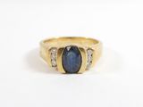 gros plan d'une bague en or avec une pierre bleue