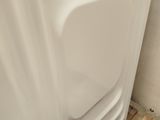 a white bath tub sitting in a bathroom next to a wooden pallet