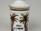 un récipient blanc orné d'un motif représentant un palmier