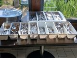 Plusieurs plateaux d'argenterie sont posés sur une table devant une fenêtre