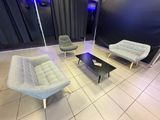 trois chaises et une table dans une pièce dont l'un des murs est noir