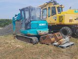 a blue and yellow construction vehicle parked in a field