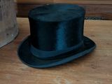 a black top hat sitting on top of a wooden table