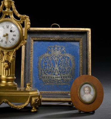 une horloge en or posée à côté d'une photo d'une femme