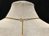 a white mannequin with a gold chain and a gold ball on it