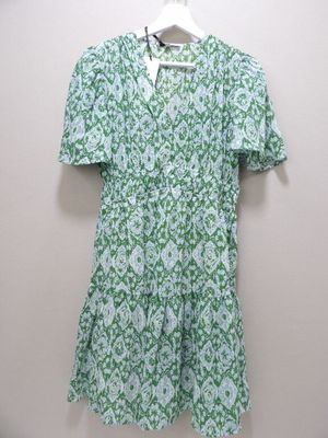 une robe à fleurs verte et blanche suspendue à un cintre