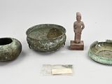 Plusieurs objets anciens sont exposés sur une surface blanche