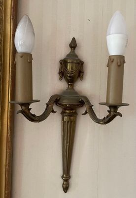 a picture of a wall mounted light with two candles on it