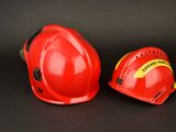 pair of red hard hats on a black background