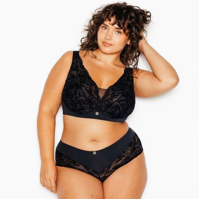 une femme en soutien-gorge et culotte noirs posant pour une photo