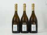 trois bouteilles de vin sont alignées sur une surface blanche