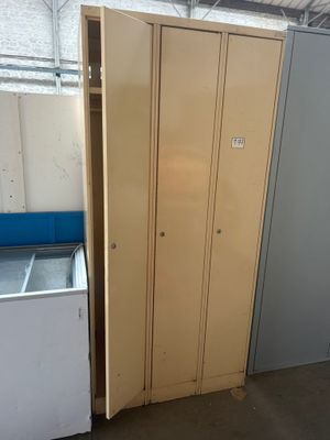 une armoire et un réfrigérateur dans une pièce avec un mur
