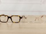 two pairs of glasses sitting on top of a wooden table