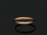 a close up of a gold ring on a black surface