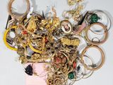a pile of gold and silver jewelry on a white surface