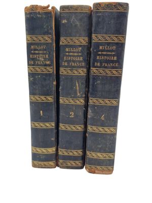 three old books sitting on top of each other on a white surface