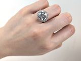 la main d'une femme tenant une bague sertie d'un diamant