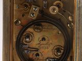 an antique brass clock with roman numerals and a glass case