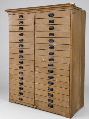 une vieille commode en bois avec de nombreux tiroirs et des poignées noires