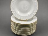 a set of six white and gold dinner plates
