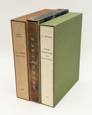 three books are stacked on top of each other on a white surface