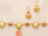 an image of a necklace and earring set with a coin