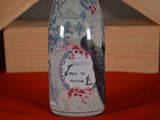 a bottle with a bird on it sitting on a table