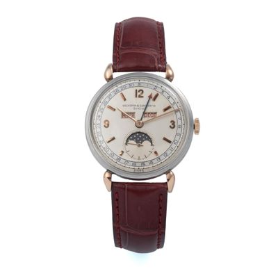 un gros plan d'une montre-bracelet avec un cadran blanc et un bracelet en cuir marron
