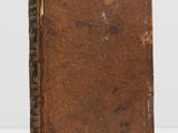 an old book sitting on top of a white surface