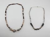 two necklaces with black, white and brown beads on a white background