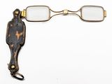 une paire de lunettes et une paire de ciseaux posés sur une surface blanche