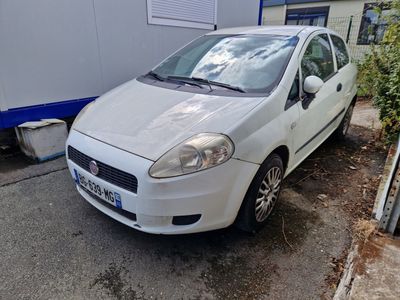 une petite voiture blanche garée sur le bord de la route