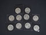 six pièces d'argent de 25 cents sont disposées en pyramide sur une surface noire