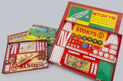 Plusieurs types de jouets différents se trouvent dans une boîte posée sur une surface grise.