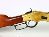 a rifle with a wooden handle and brass plated body