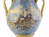 un grand vase avec un tableau posé sur une table