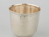 a silver cup on a white surface with a white background