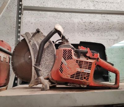 une tronçonneuse posée sur une étagère dans un garage