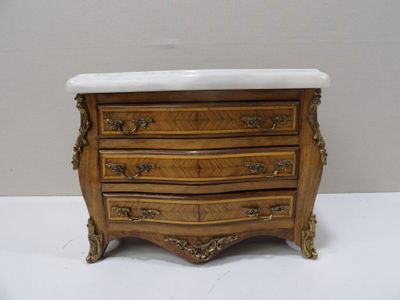 a small chest of drawers with a marble top